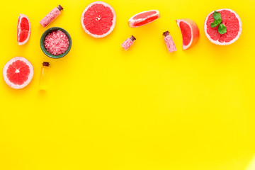 Homemade spa with grapefruit salt in natural cosmetic set fruit yellow background top view mock up