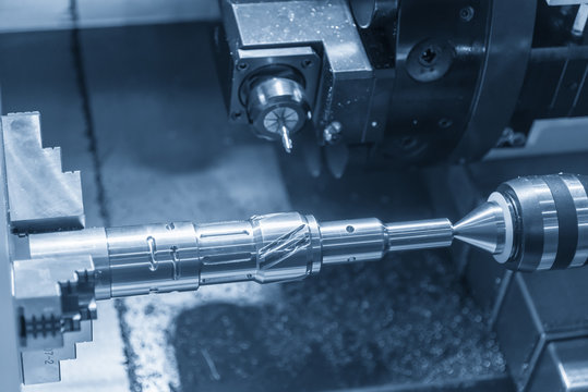 The CNC lathe machine cutting the metal rod by milling spindle.