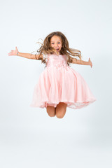 Naklejka premium Bambina castana in abito rosa che salta