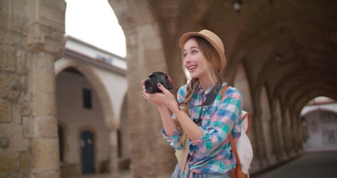 Young woman tourist taking photos of ancient medieval building