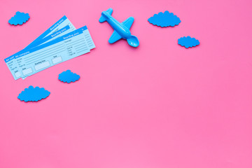 Sample of airplane ticket. Family trip with kid. Airplan toy and paper clouds. Pink background flat lay space for text