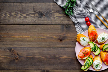 Mini sandwich set with french baguette, cheese, fish and avocado on wooden background top view mock up
