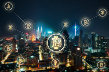 Bitcoins and blockchain network connection with blur night city background .Electronic money ,blockchain transfers and finance concept.