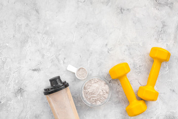 protein powder for fitness nutrition to start training and bars on gray background top view mock-up