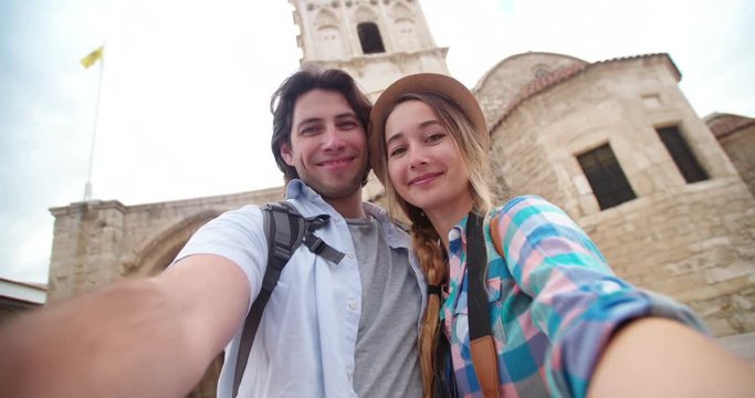 Young tourists taking a smiling selfie in picturesque stonebuilt village