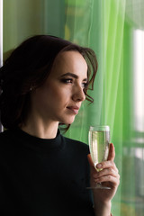 beautiful woman holding champagne glass green background