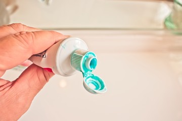 A hand holding a messed up toothpaste tube