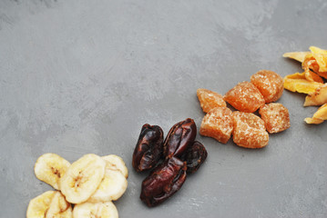 Assortment of Dried Fruits: Banana, Ginger, Mango over Gray Background with copy space.