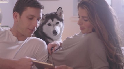 Young loving couple laying on there bed while their dog relaxes with them - Powered by Adobe