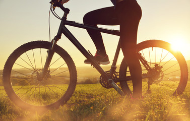 Obraz premium Cyclist on a bicycle in the sunset. Healthy lifestyle concept.