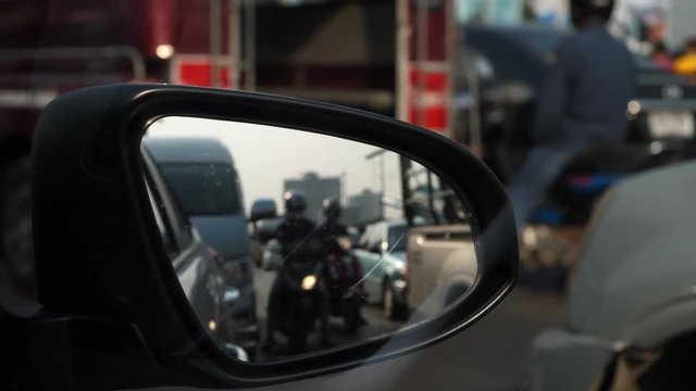 traffic jam in rush hour of city life, focus on side mirror of vehicle car