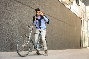Businessman on a bike. Business man sitting on bike and talking on smart phone.