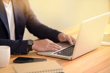Portrait of young man sitting at his desk in the office