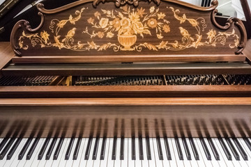 Fototapeta na wymiar Keyboard of a luxurious modern expensive grand piano with an open lid inlaid