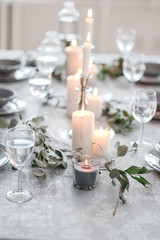Wedding or festive table setting. Plates, wine glasses, candles and cutlery