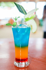 colorful rainbow alcohol cocktail and apple topping