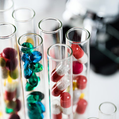 Laboratory Microscope, pills and test tubes. Scientific and healthcare research background.