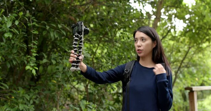 Woman holding digital camera for recording vlog at outdoor