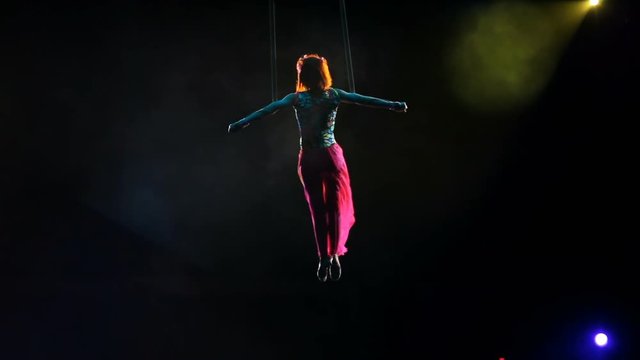 Air gymnast on canvases in circus