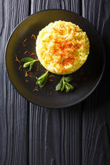 Delicious Italian risotto with saffron and mint (Risotto alla milanese) closeup. Vertical top view from above