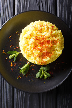 risotto from rice carnaroli with saffron and mint closeup. Vertical top view from above