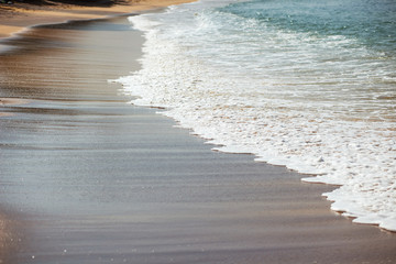 Waves lapping on the black sand