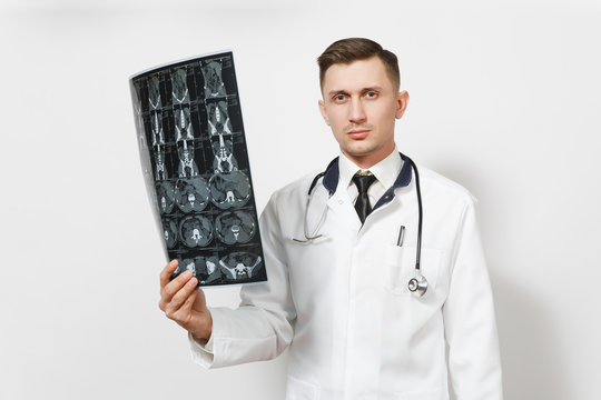 Serious handsome young doctor man holds x-ray radiographic image ct scan mri isolated on white background. Male doctor in medical uniform, stethoscope. Healthcare personnel, health, medicine concept.