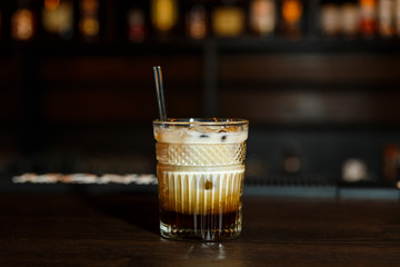 A horizontal image of a white russian cocktail in rocks glass in a bar. - 197601579