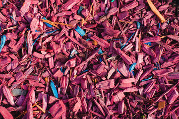 Textured background decorative colored sawdust for finishing flowerbeds in the winter season. Red and maroon sawdust