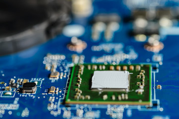 Obraz premium Closeup on electronic board in hardware repair shop, applying thermal paste to the processor. soft focus. Shallow DOF