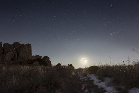 Full moon rising over the hill on a winter night