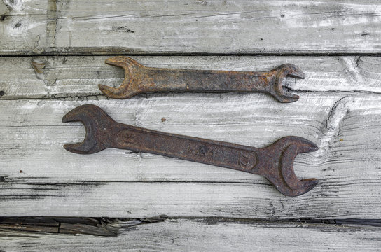 Two spanners on an old wooden table