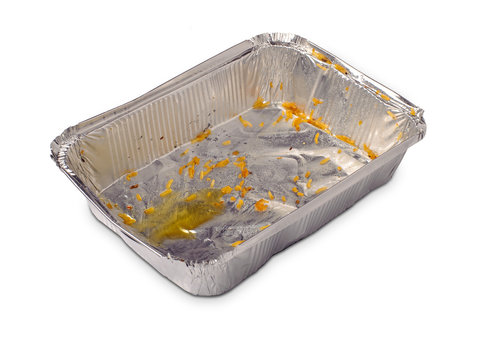 Empty dirty foil dish with rice grains and oil