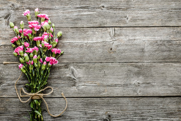 Spring flowers on table on wooden old background, mothers day card or wedding invitation with blank space