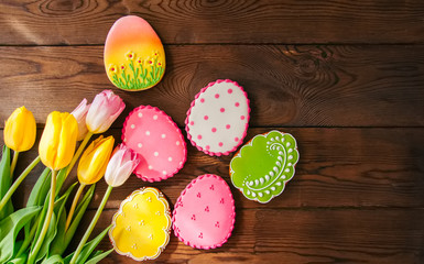 Colorful Easter bunny and egg cookies in a basket on a wooden background