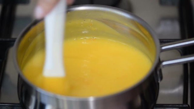 Freshly prepared lemon kurd - custard on fruit juice, in a saucepan whipped with whisk