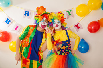 Clowns are a boy and a girl in bright costumes at the child's birthday. The explosion of emotions and the fun of the circus