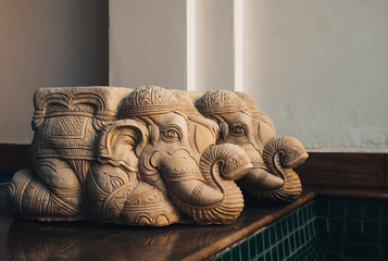 Two Old mortar elephant statue kneeling on the wooden floor inside swimming pool at the home, Vintage