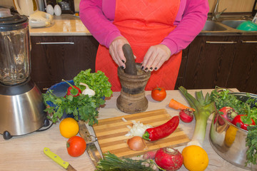 Woman's hands cooking healthy meal in the kitchen, behind fresh vegetables