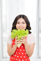 portrait of attractive caucasian smiling woman isolated on kitchen shot eating salat