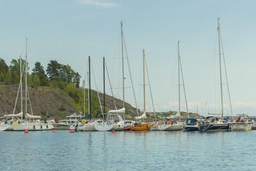 Fototapeta premium Boats and yachts in the harbour seen from the Vallisaari island on a bright summer day in Southern Finland