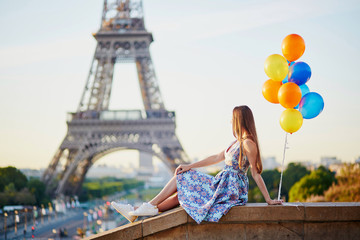 Young woman with bunch of balloons near the Eiffel tower