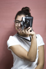 Attractive girl holding a retro camera.