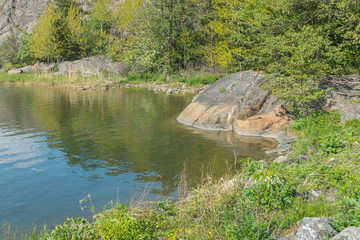 Obraz premium A rocky shore with bushes and trees on the Kuninkaansaari island in the Gulf of Finland, Baltic sea, Europe