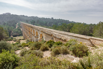 The Ferreres Aqueduct profile view with tourist walking