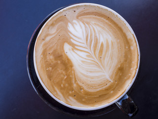 Close up shot of a latte coffee with leaf shap art