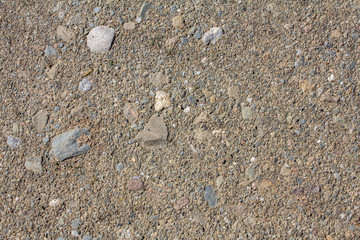 Close up of rounded and polished beach rocks and sand.