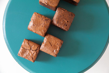 Chocolate dessert, cut into cubes on a bright background.