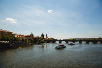 PRAGUE,CZECH REPUBLIC - JUNE 23, 2017: view of Charles bridge and Vltava river with boats in Prague, Czech Republic