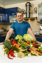 Man with a large variety of vegetables, ready to be cooked